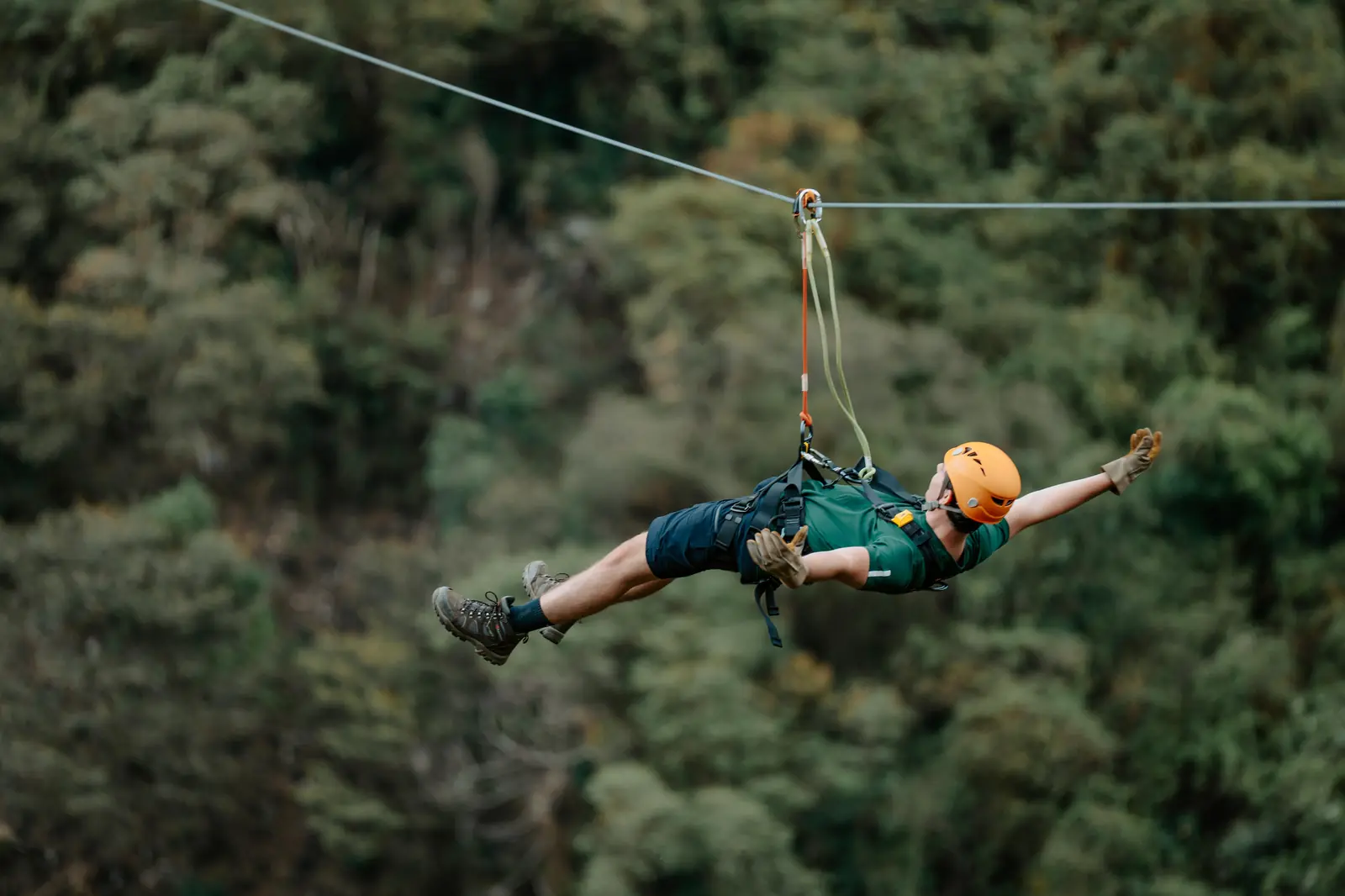 Rider flying superman style on a zipline cable above the cloud forest in Lucmabamba, Cusco