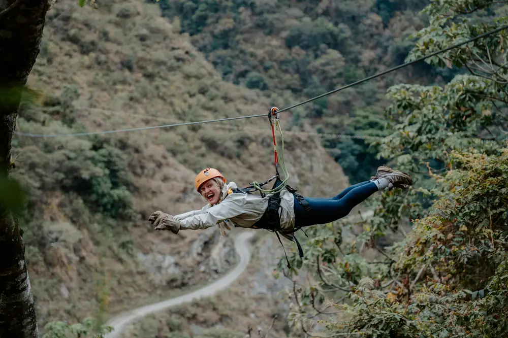 Rider on the zipline above the road and the Salkantay river valley